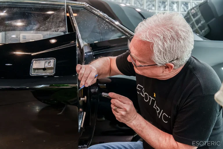 Todd Cooperider of ESOTERIC detailing the door of a black 1970 Plymouth 'Cuda during the Winter Residency